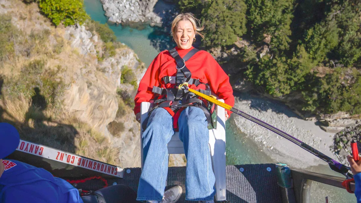 A jumper released from the canyon swing platform above the Shotover — Queenstown adventure activities, New Zealand