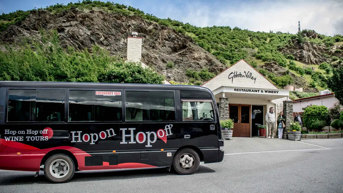 A hop-on hop-off wine bus at a Gibbston Valley stop — Gibbston Valley wine tour, Queenstown, New Zealand