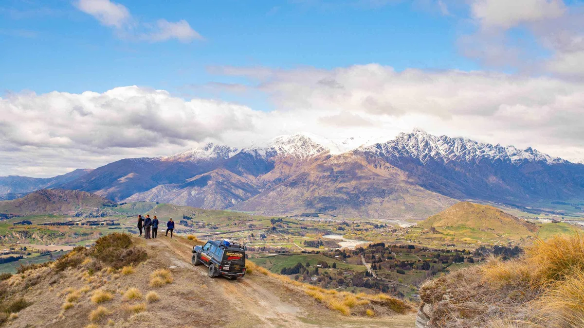A 4WD on the cliff-edge Skippers Canyon Road above the river — Glenorchy from Queenstown, New Zealand