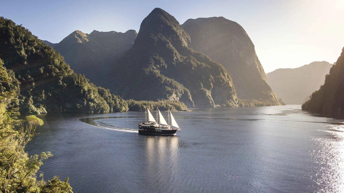 A wilderness cruise boat under low cloud in Doubtful Sound — Doubtful Sound from Queenstown, New Zealand